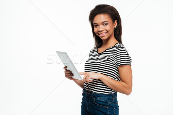 Stock photo: Happy young african woman using tablet computer.