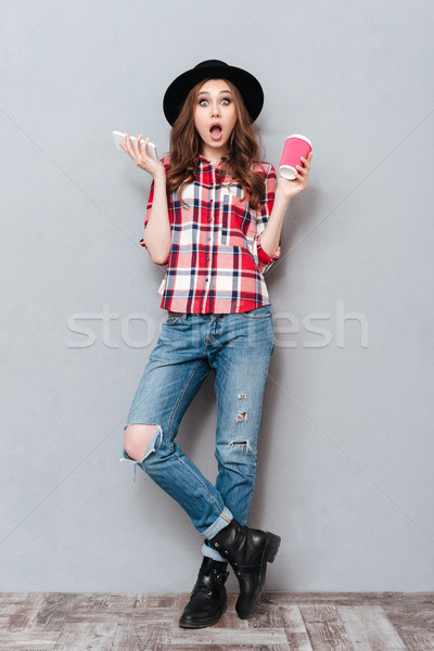 Full length portrait of a shocked girl in plaid shirt Stock photo © deandrobot