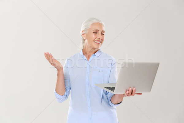 Funny mature woman using laptop computer isolated over white Stock photo © deandrobot