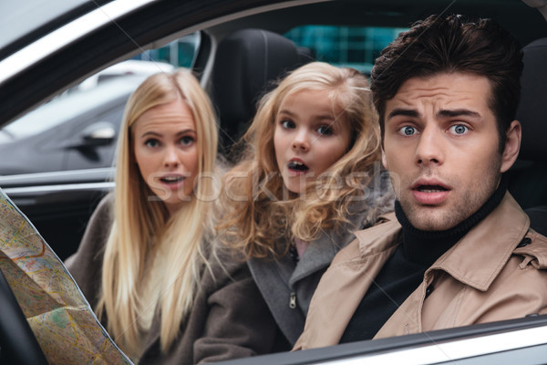 Stock photo: Shocked scared young family holding map.