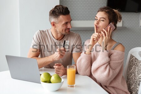 Portrait of a cheery young couple shopping online Stock photo © deandrobot