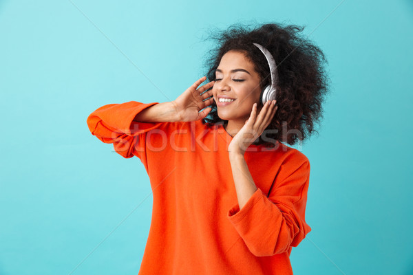 Young american woman 20s with shaggy hairdo enjoying music via w Stock photo © deandrobot