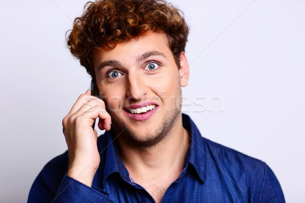 Surprised man in casual cloth talking on the phone Stock photo © deandrobot