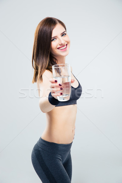 Sporty woman giving glass of water on camera Stock photo © deandrobot