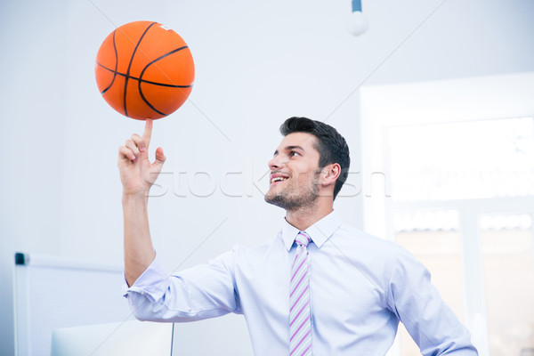 Smiling businessman spining ball in office Stock photo © deandrobot