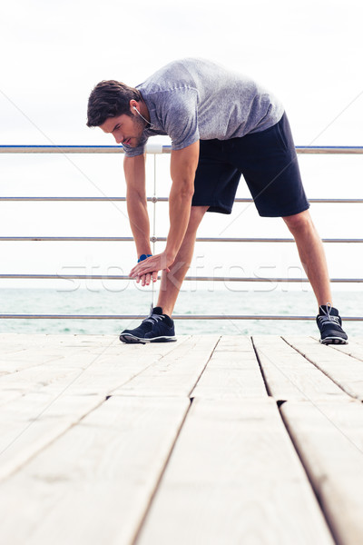 Man stretching outdoors Stock photo © deandrobot