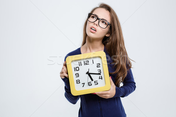 Thoughtful cute woman holding wall clock Stock photo © deandrobot