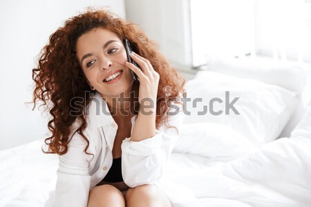 Szczęśliwy kobieta długie włosy bed portret patrząc Zdjęcia stock © deandrobot