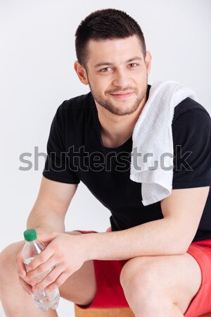 Happy sports man holding bottle with water Stock photo © deandrobot