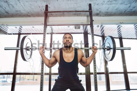 Handsome muscular weightlifter at gym doing squats Stock photo © deandrobot