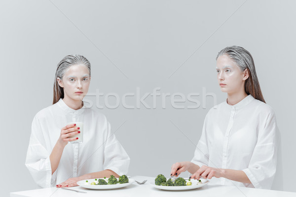 Two girls having a meal at the table Stock photo © deandrobot