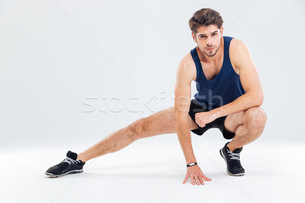 Attractive young male athlete stretching his legs Stock photo © deandrobot