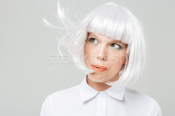 Attractive playful young woman blowing on her blonde hair Stock photo © deandrobot
