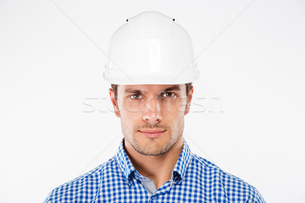Portrait of serious young man architect in building helmet Stock photo © deandrobot