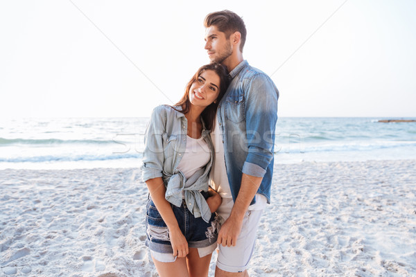Couple standing and dreaming on the beach together Stock photo © deandrobot
