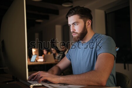Busy caucasian bearded businessman working late at night with co Stock photo © deandrobot