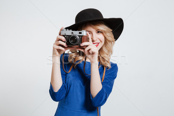 Amazing woman dressed in blue dress wearing hat holding camera Stock photo © deandrobot