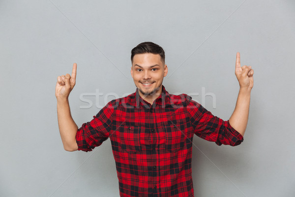 Glimlachend jonge man wijzend foto shirt kooi Stockfoto © deandrobot