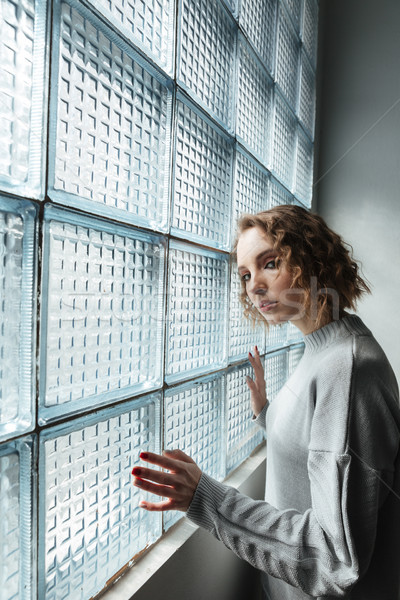Jeune femme permanent fenêtre vue de côté fille cheveux bouclés [[stock_photo]] © deandrobot