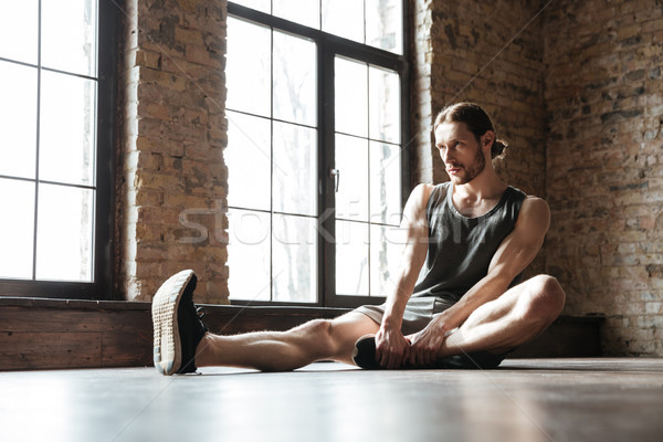 Portrait of a healthy sportsman doing stretching exercises Stock photo © deandrobot