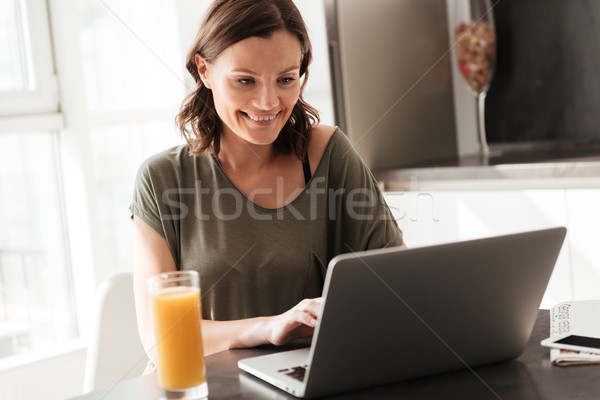 Stock photo: Smiling casual woman using tablet computer