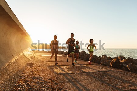 Vedere din spate grup sport oameni funcţionare în aer liber Imagine de stoc © deandrobot