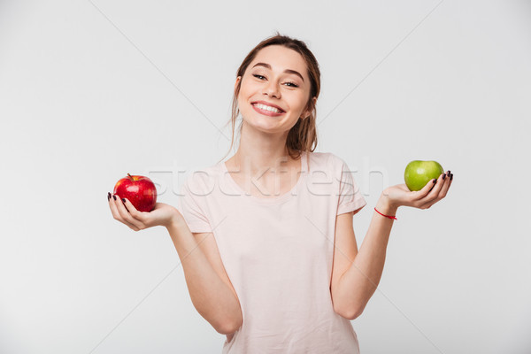 Portrait of a joyful happy girl holding apples Stock photo © deandrobot