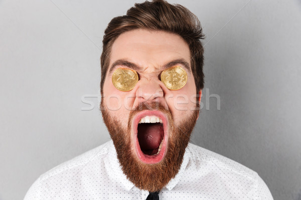 Close up of a happy businessman with bitcoins in his eyes Stock photo © deandrobot