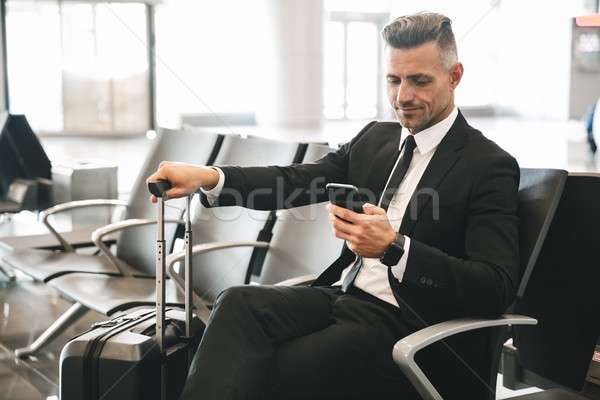 Smiling mature businessman using mobile phone Stock photo © deandrobot