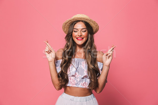 Image of beautiful woman in straw hat holding fingers crossed an Stock photo © deandrobot