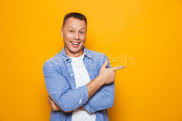 Portré boldog középkorú férfi mutat ujj izolált Stock fotó © deandrobot