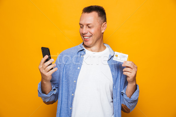 Portré elégedett középkorú férfi néz mobiltelefon tart Stock fotó © deandrobot