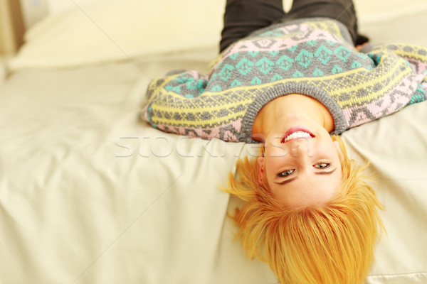 Closeup portrait of a young smiling woman lying on the bed Stock photo © deandrobot