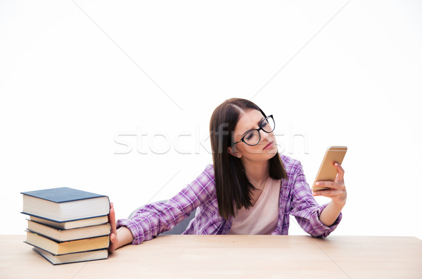 Female student push out books and using smartphone  Stock photo © deandrobot