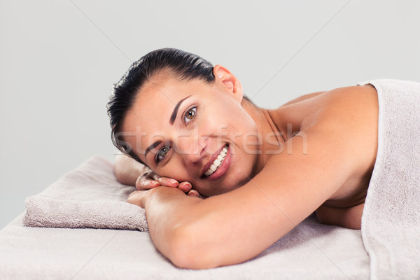 Happy cute woman lying on massage lounger Stock photo © deandrobot