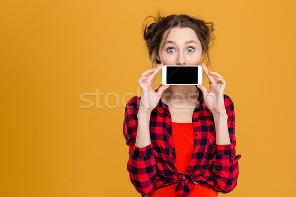 Woman covering her mouth with blank smartphone screen Stock photo © deandrobot