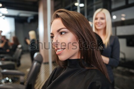 Woman with smartphone and hairdresser making hair styling at salon Stock photo © deandrobot
