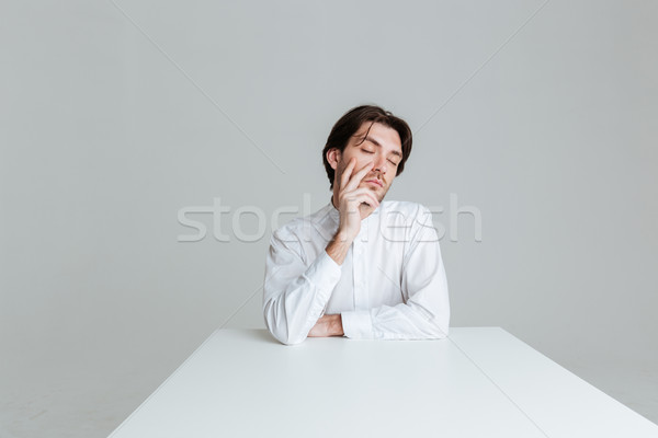 Man with eyes closed thinking about something at the table Stock photo © deandrobot