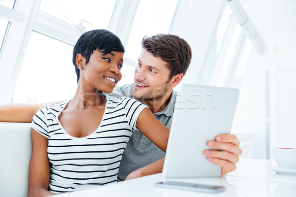 Portrait of a happy couple using tablet computer in restaurant Stock photo © deandrobot