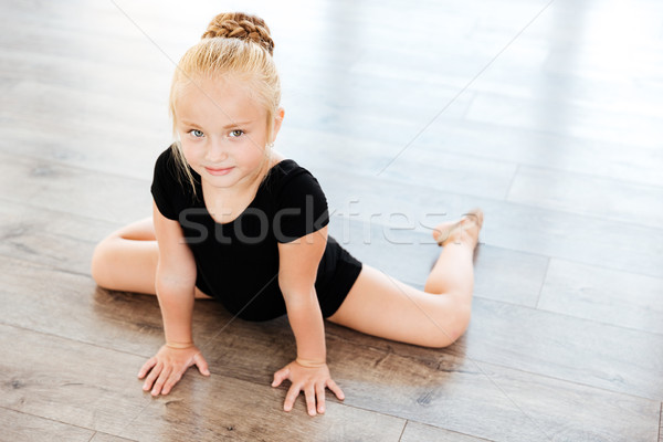 Little girl ballerina stretching in dance studio Stock photo © deandrobot