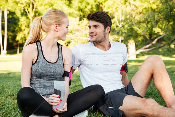 Couple resting after training and drinking water in the park Stock photo © deandrobot