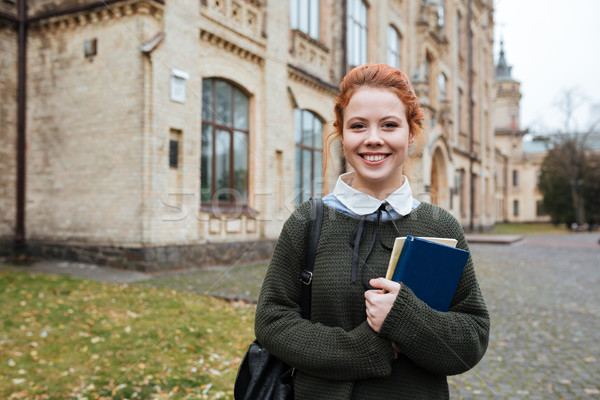 Young woman student with backpack and books standing in campus Stock photo © deandrobot