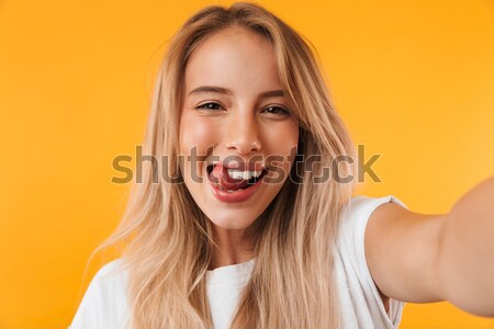 Cheerful charming young woman touching her lips Stock photo © deandrobot