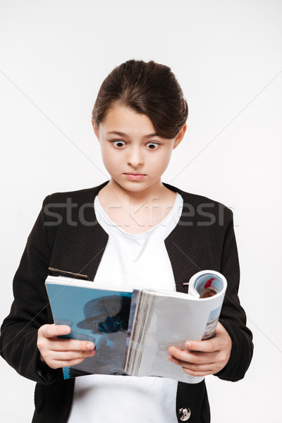 Confused young girl holding magazine Stock photo © deandrobot