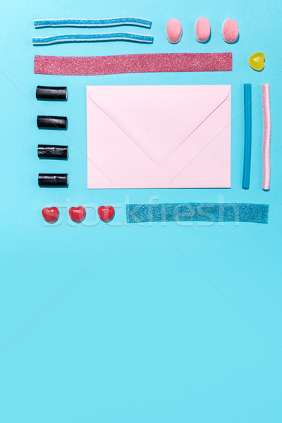 Photo of blank paper envelope with colorful sweet sugar candies Stock photo © deandrobot
