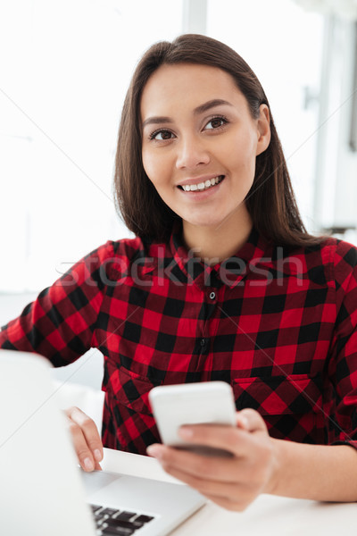 Happy caucasian lady sitting in office using laptop computer Stock photo © deandrobot