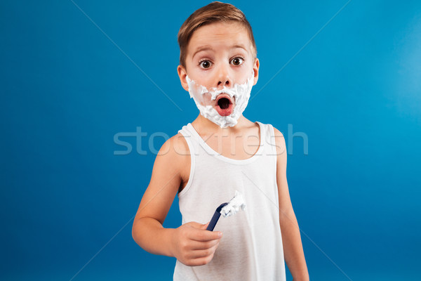 Shocked young boy in shaving foam like man holding razor Stock photo © deandrobot