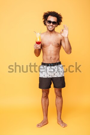 Full-length image of Happy naked man in shorts, unusual sunglasses Stock photo © deandrobot