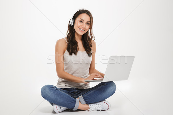 Imagem bela mulher ouvir música fones de ouvido laptop Foto stock © deandrobot