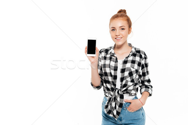 Smiling ginger woman holding arm in pocket Stock photo © deandrobot